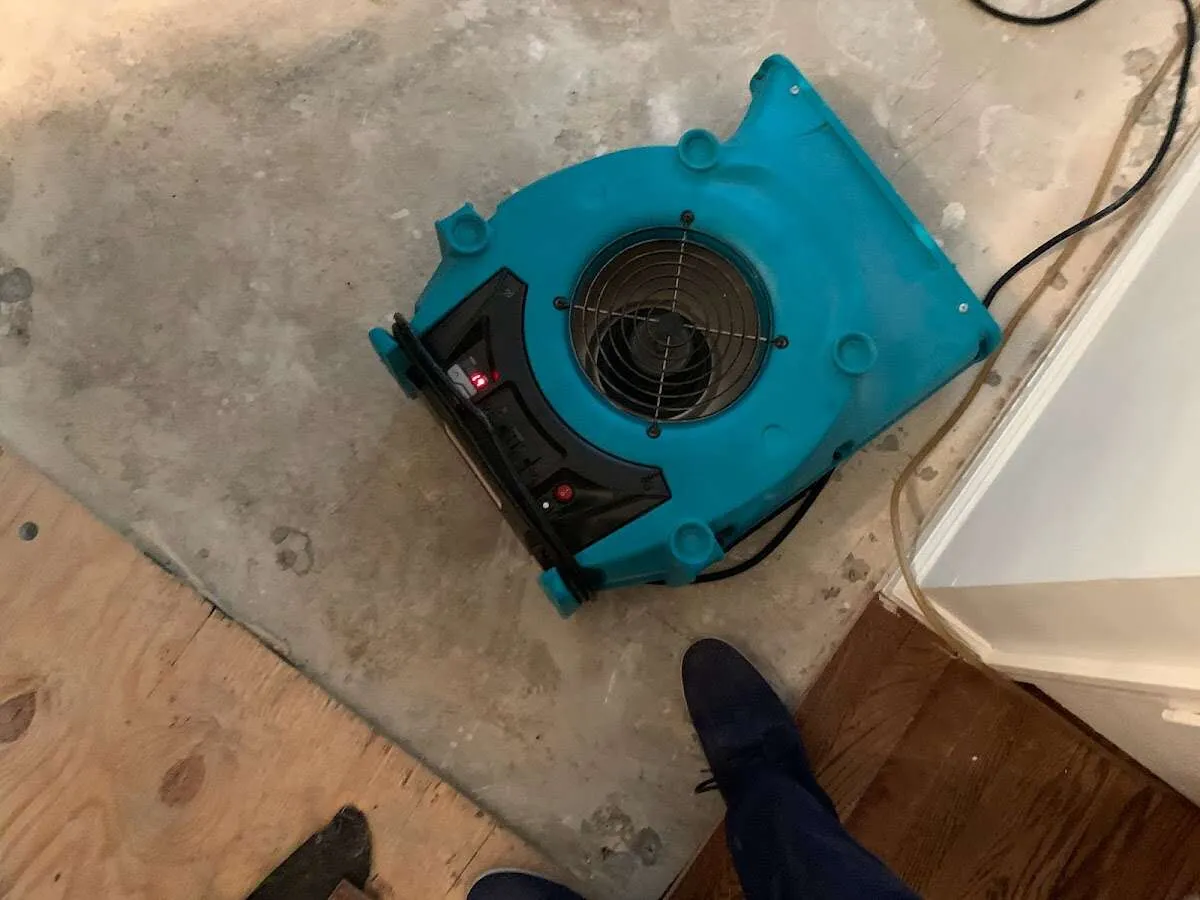 Air mover drying subfloor during Commercial Water Damage Restoration in Longview